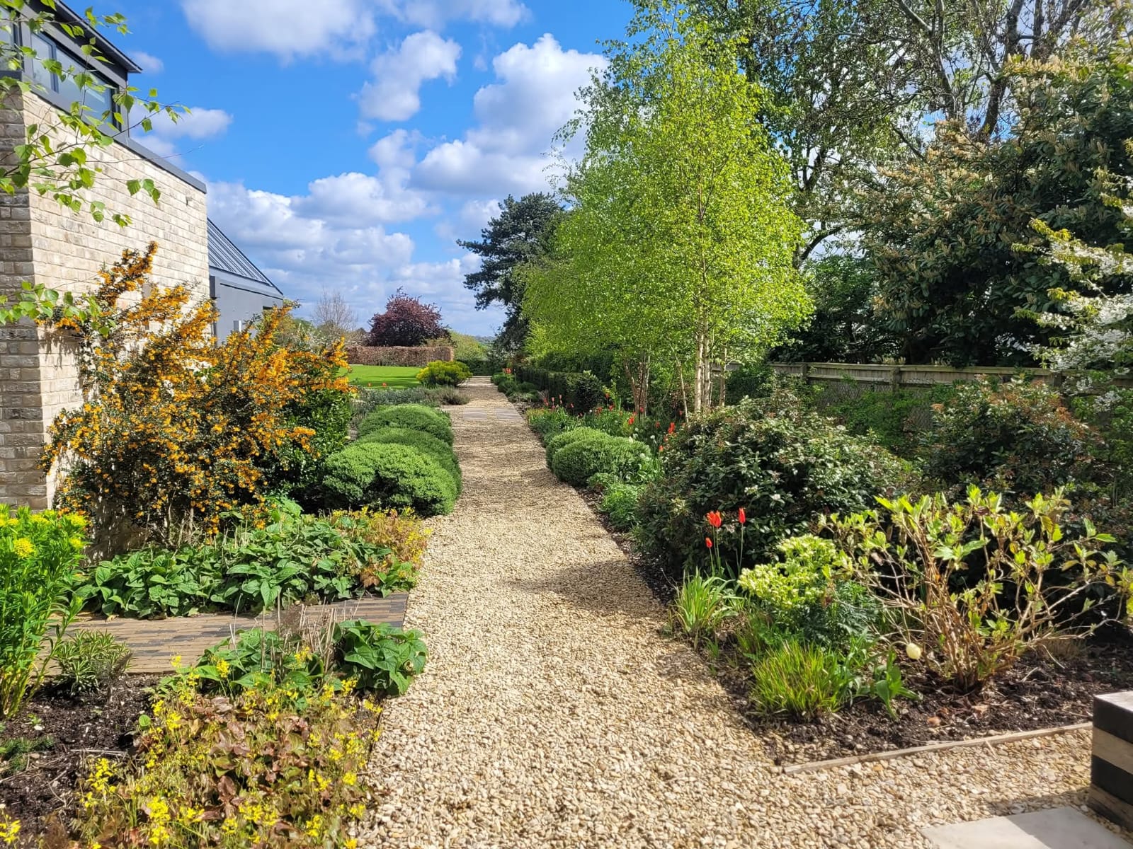 Beautifully landscaped garden with gravel pathway and topiary